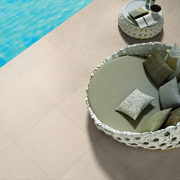 Luxe loungestoel bij strak zwembad met keramische tegels